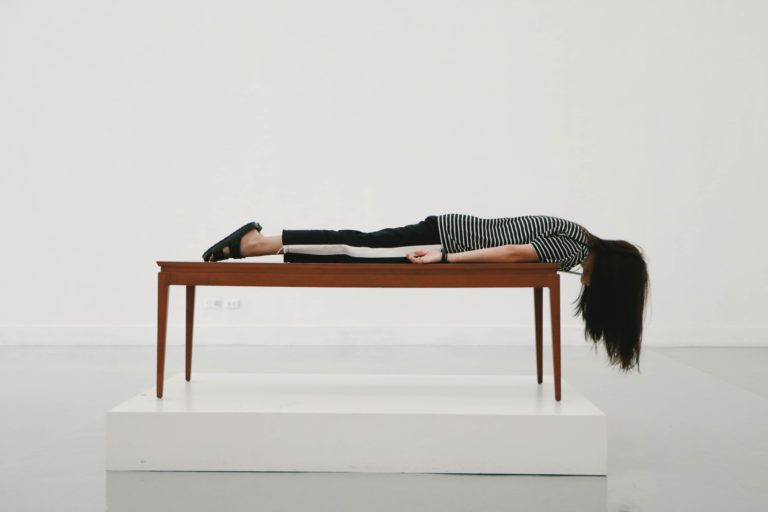 Woman laying facedown on a table looking defeated
