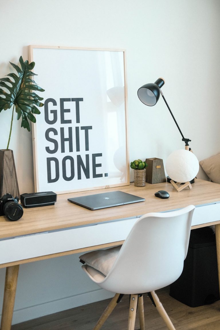 Modern desk with large poser that reads "Get Shit Done"